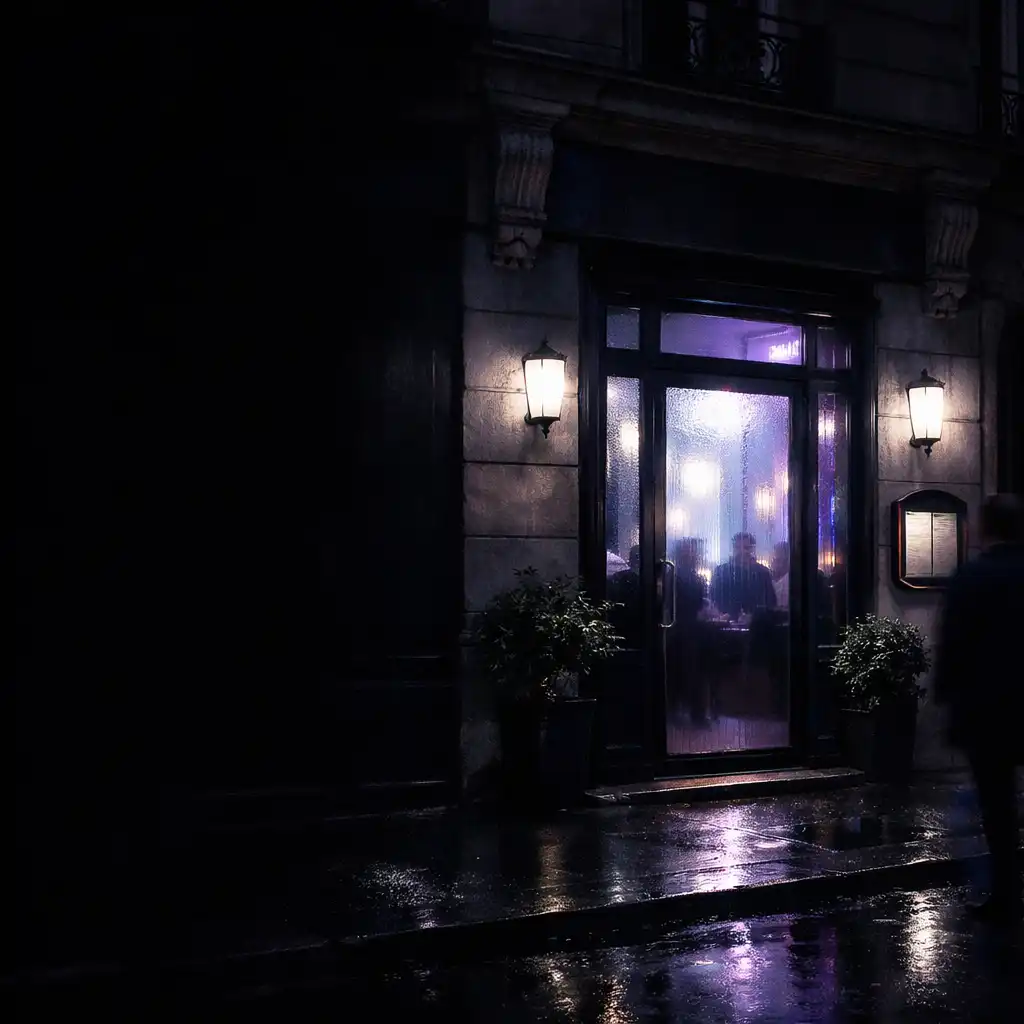 Entrée nocturne d'un restaurant parisien, éclairée d'une lumière opaline